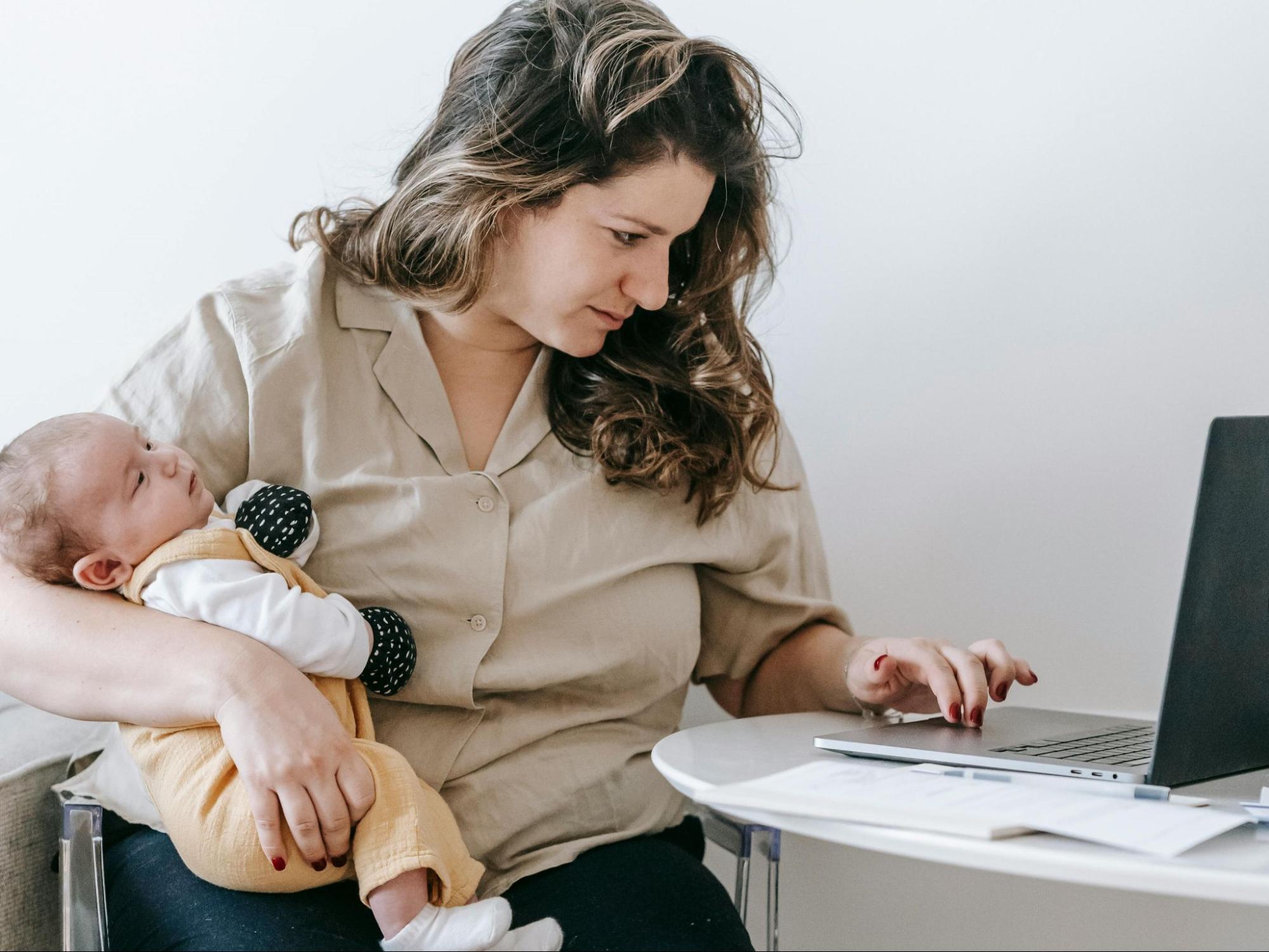 mom holding a child while working